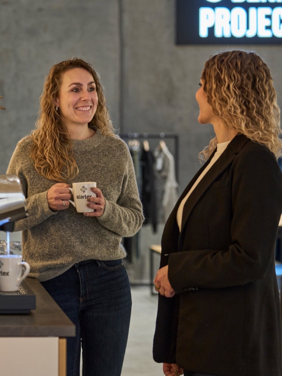 Two STARTEX colleagues talking by the coffee machine