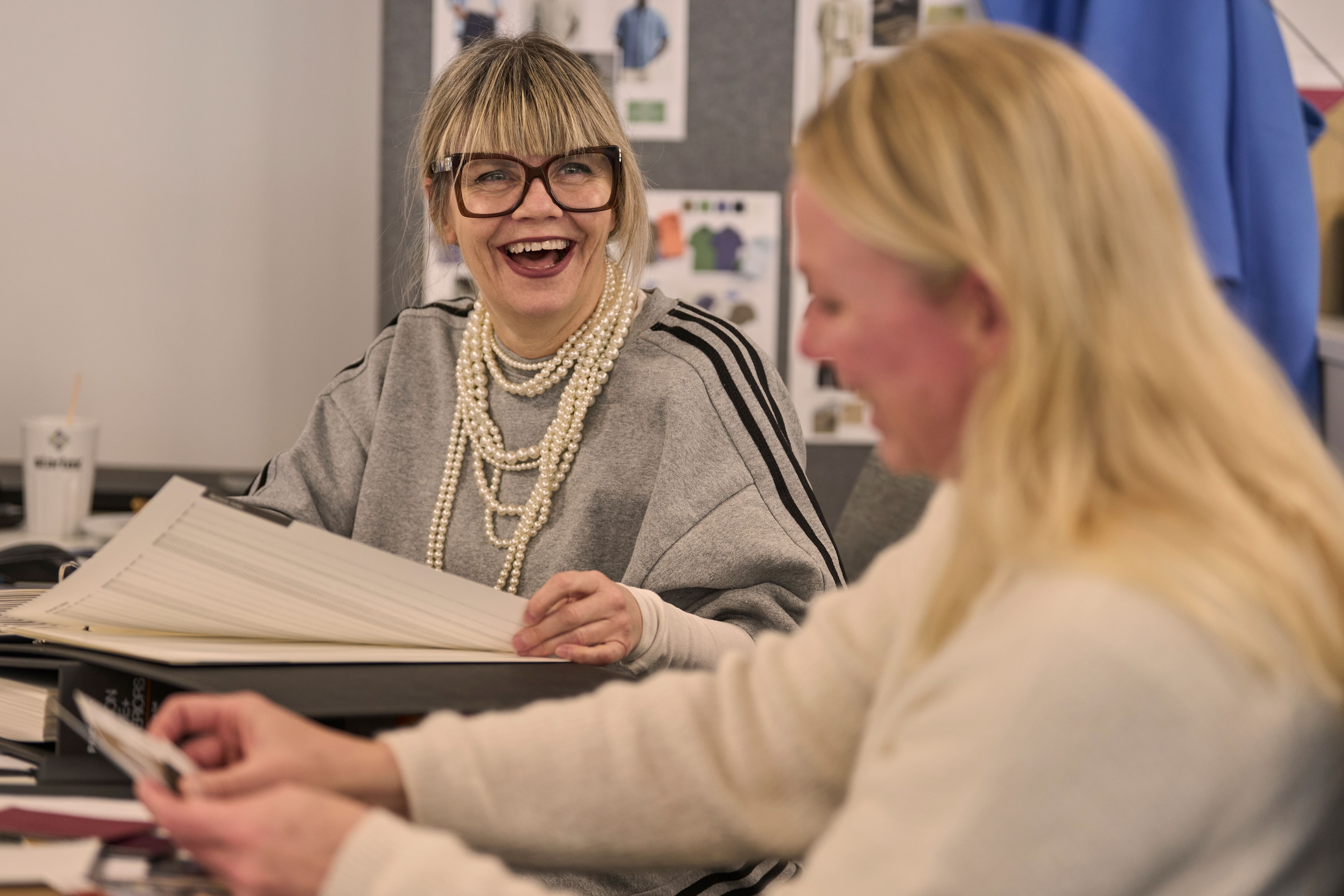 STARTEX colleagues laughing together while reviewing designs